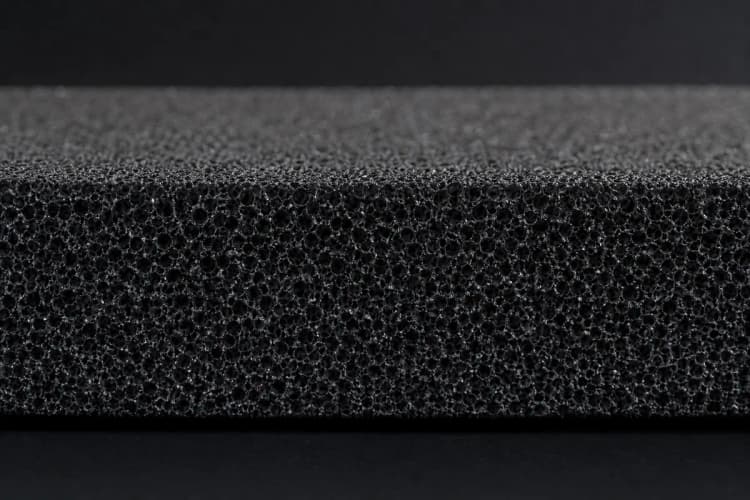 Close-up de material de isolamento acústico dentro de uma divisória, mostrando a textura e densidade.