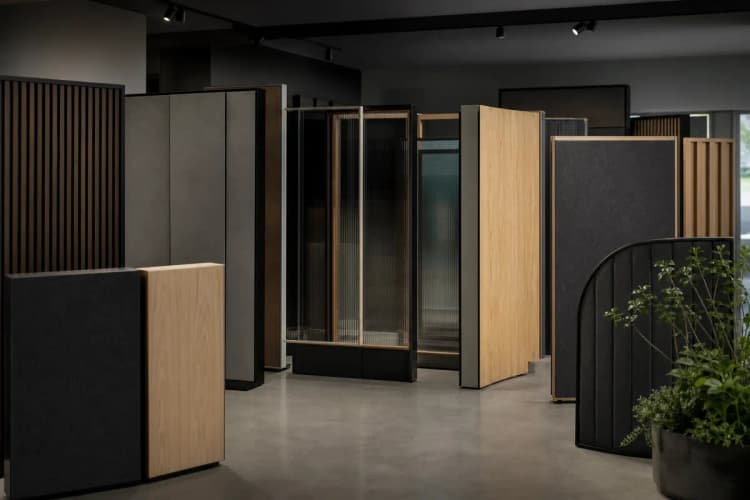 Variedade de painéis de divisórias acústicas em diferentes materiais e cores em exposição.